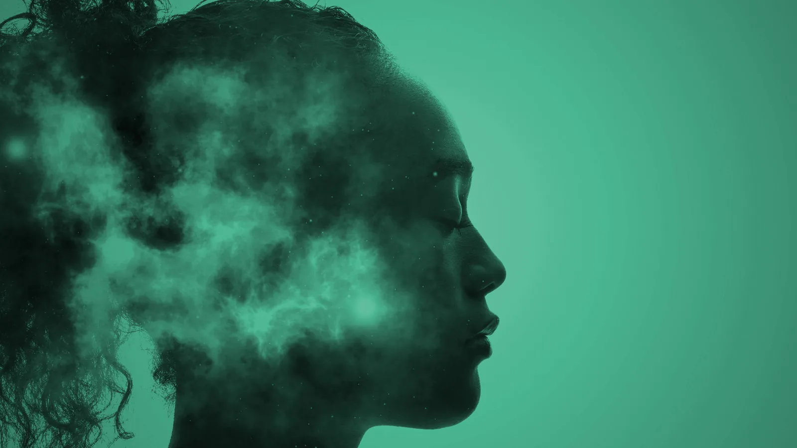 Double exposure of a woman's profile with her eyes closed, her head filled with drifting clouds, tinted green